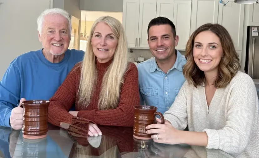 Happy multi-generational family smiling together in a bright kitchen, representing restored sleep and family time after finding the right pillow